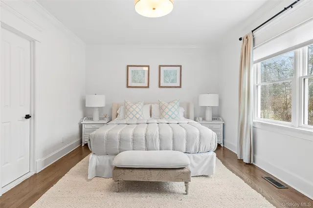 a bedroom with a bed and a large window