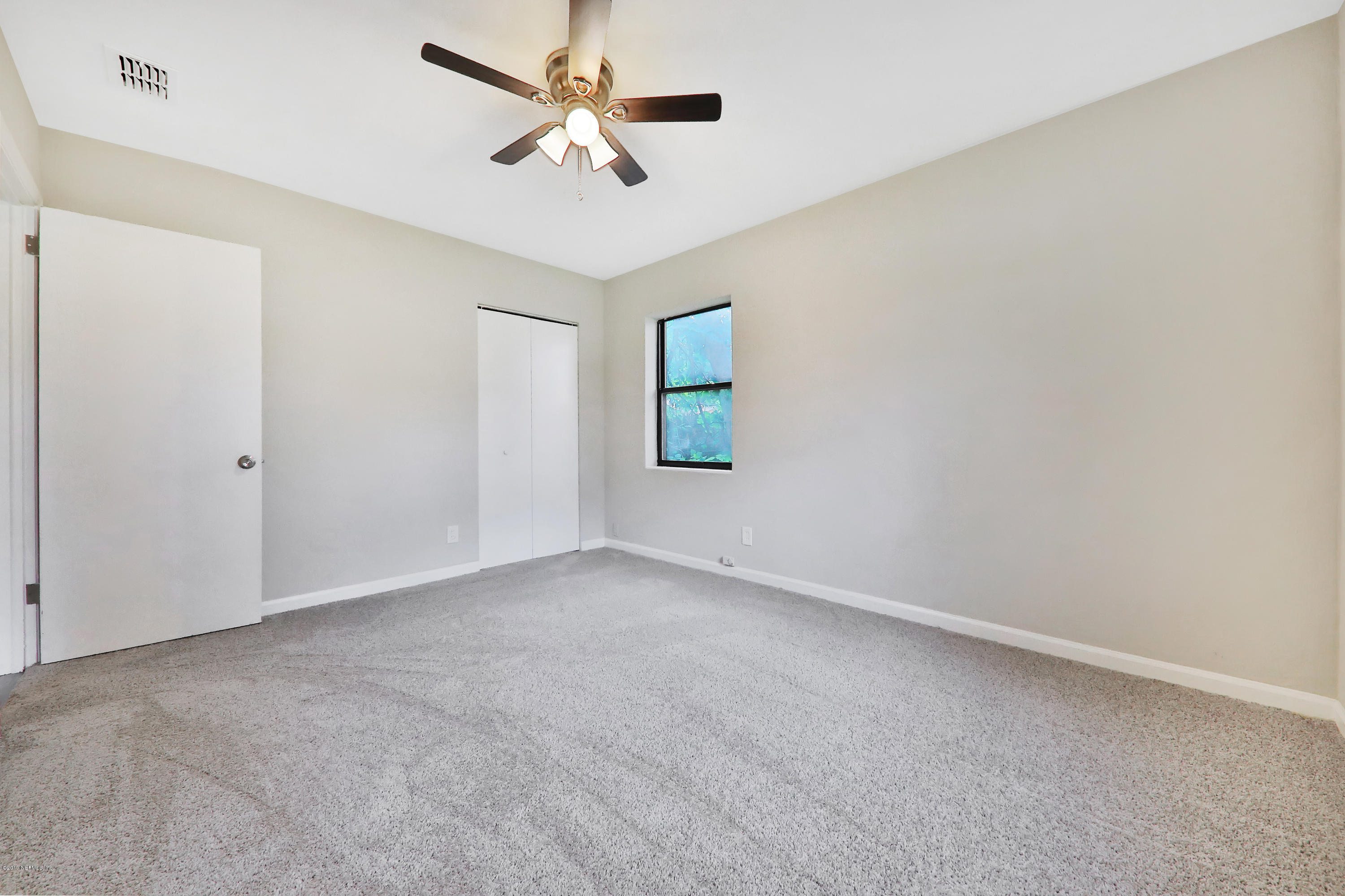10512 Stone Road Jacksonville, FL 32246 - Photo 12 of 22 an empty room with windows and fan