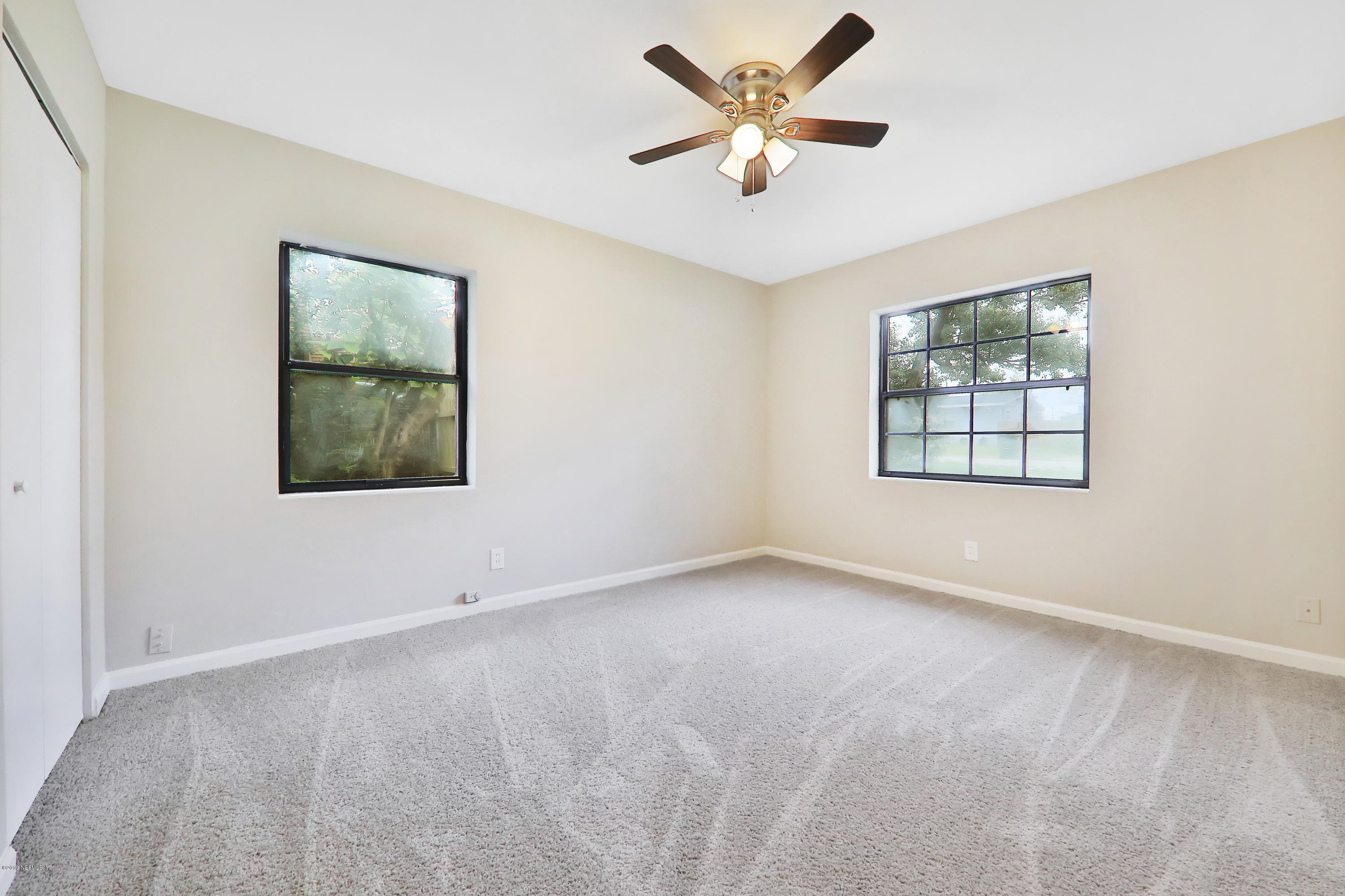 10512 Stone Road Jacksonville, FL 32246 - Photo 14 of 22 an empty room with windows and ceiling fan