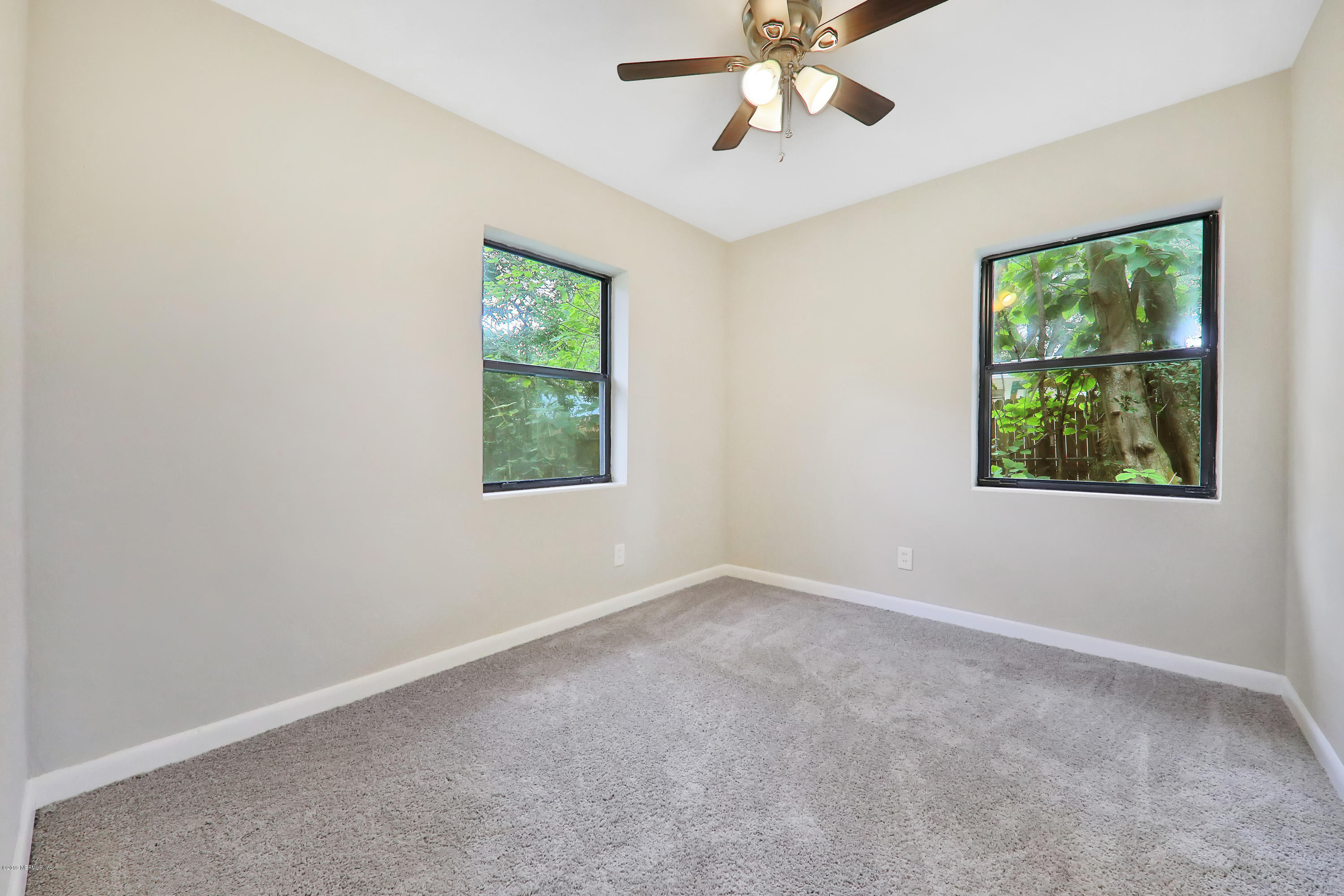 10512 Stone Road Jacksonville, FL 32246 - Photo 15 of 22 an empty room with windows and fan