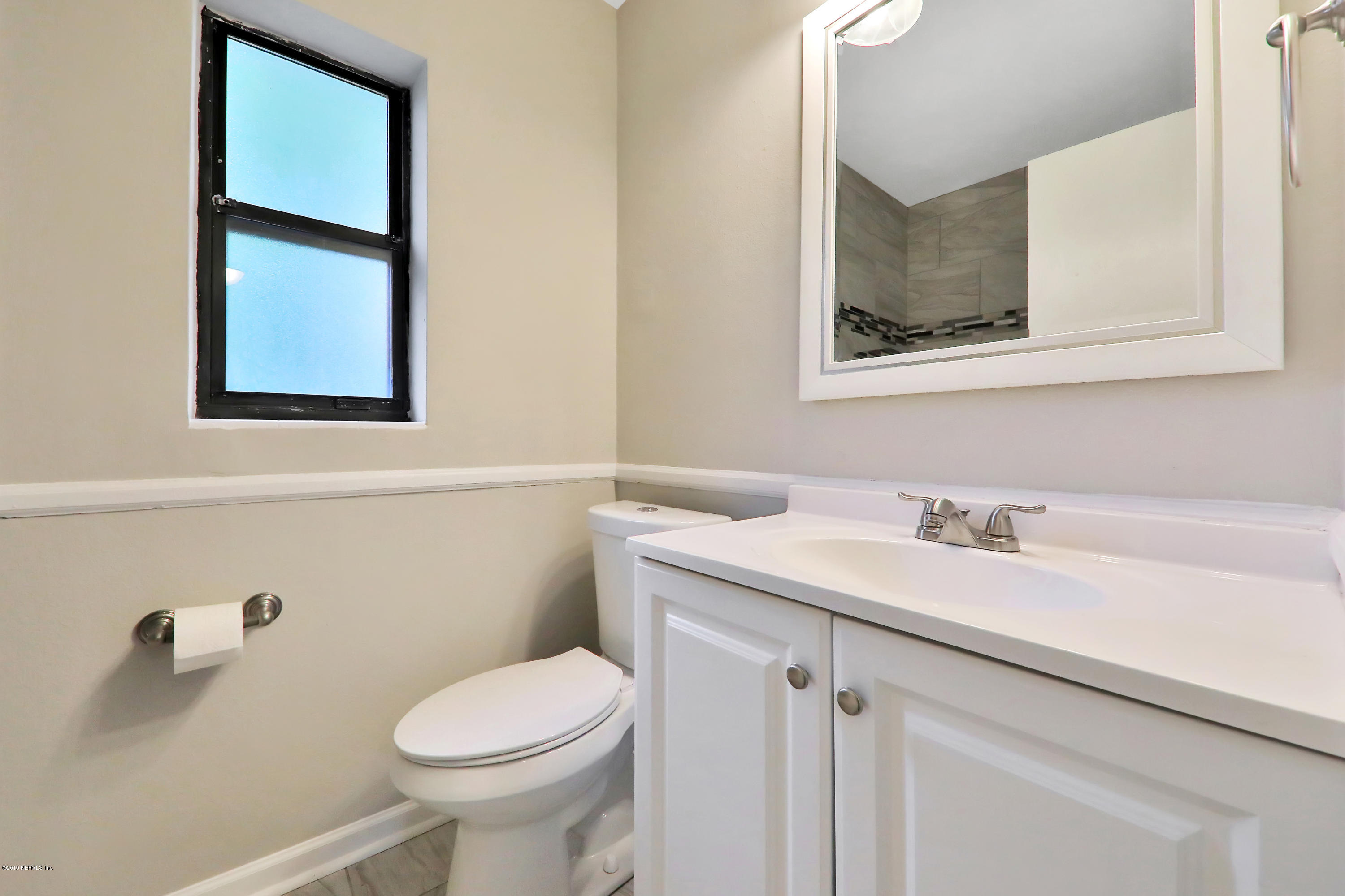 10512 Stone Road Jacksonville, FL 32246 - Photo 16 of 22 a bathroom with a toilet sink and mirror