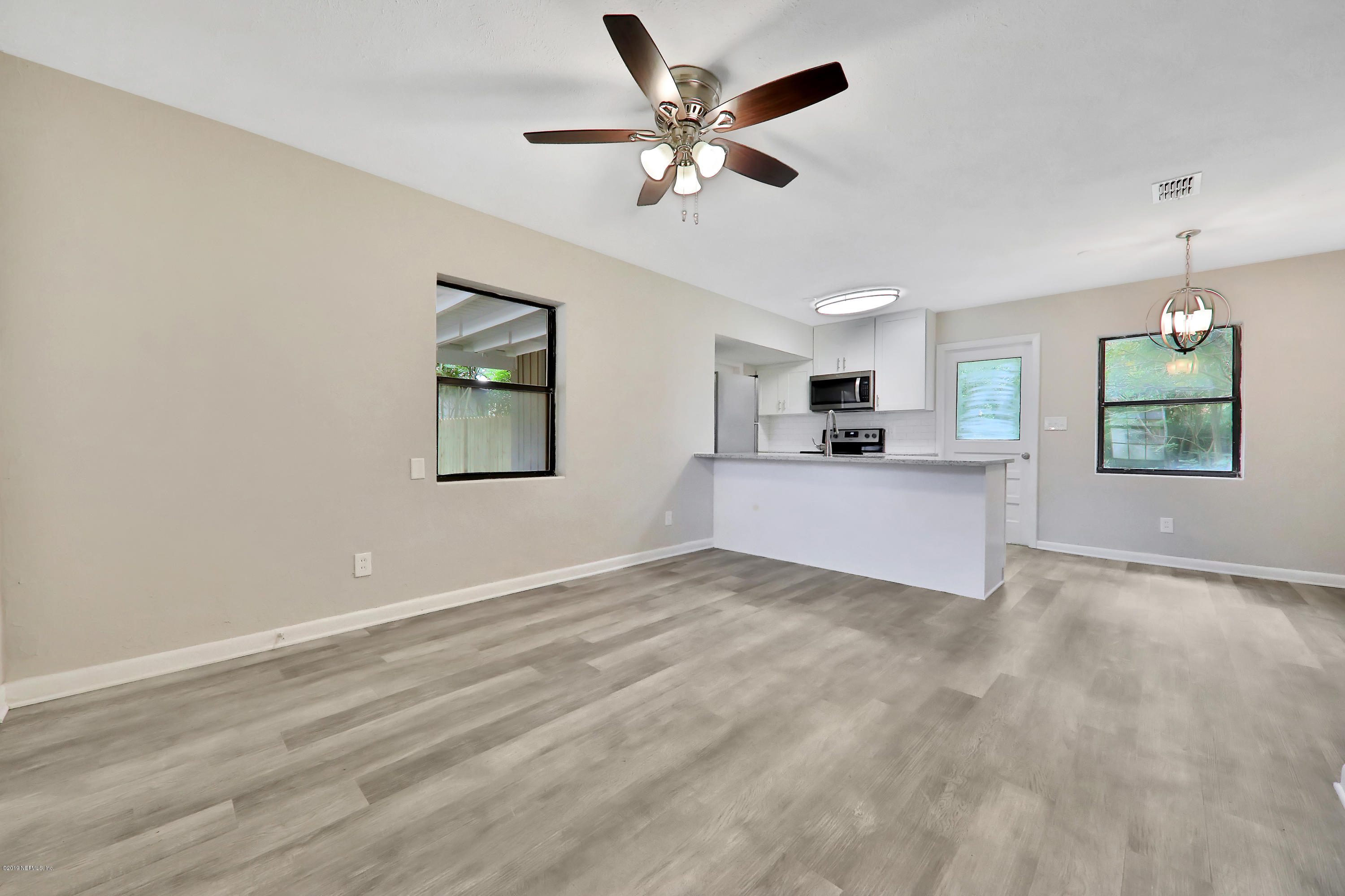 10512 Stone Road Jacksonville, FL 32246 - Photo 3 of 22 an empty room with windows and ceiling fan