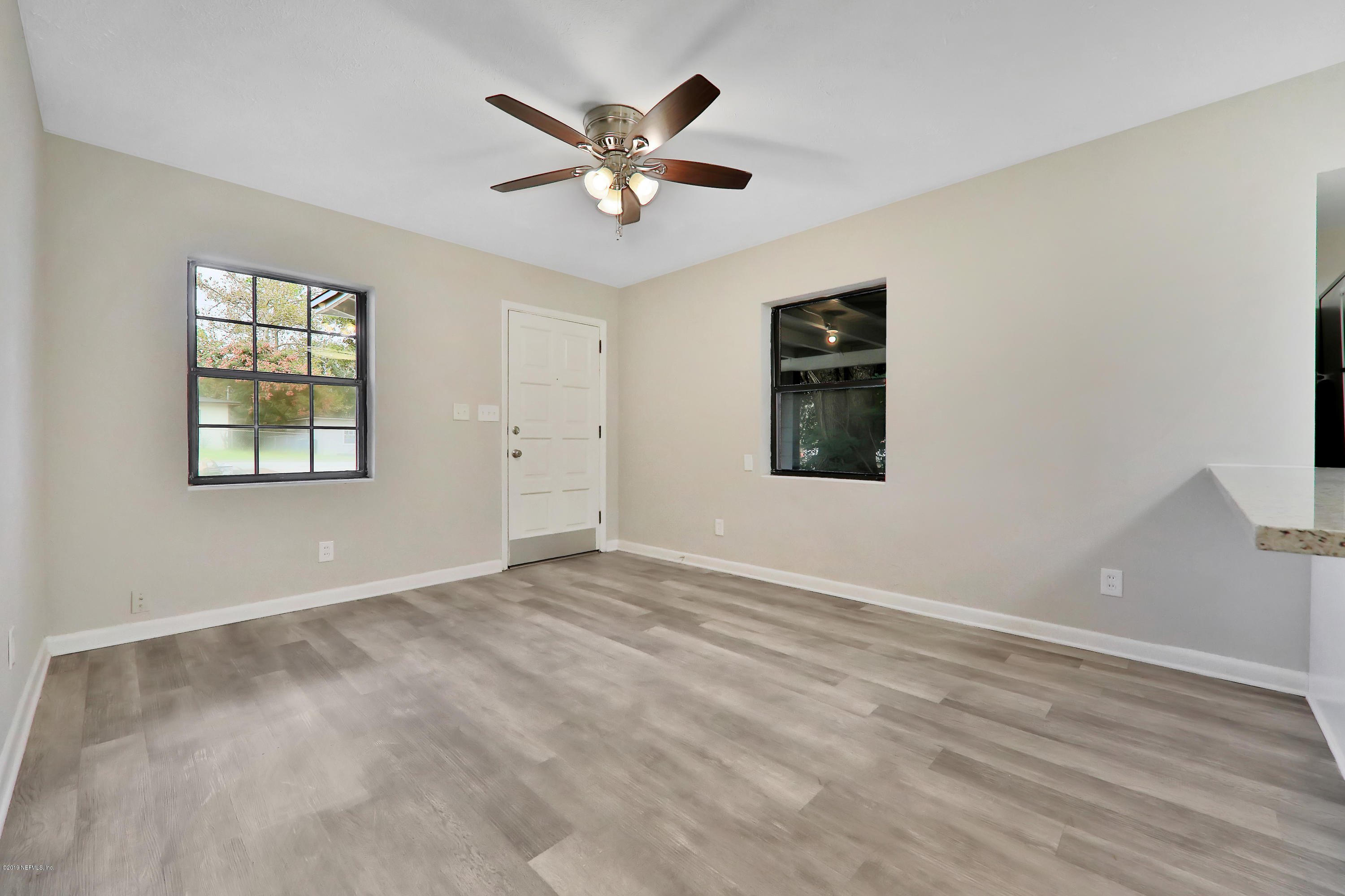 10512 Stone Road Jacksonville, FL 32246 - Photo 4 of 22 wooden floor in an empty room with a window
