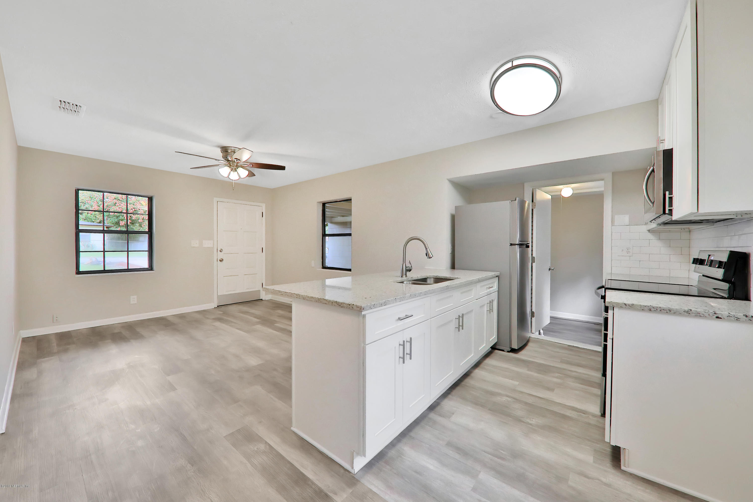 10512 Stone Road Jacksonville, FL 32246 - Photo 6 of 22 a large white kitchen with cabinets a sink and appliances