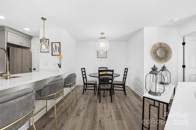 a view of a dining room with furniture a chandelier and wooden floor