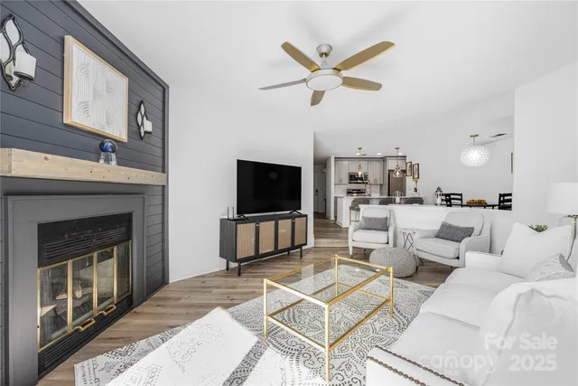 a living room with furniture a flat screen tv and a fireplace