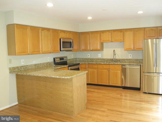 7285 Olde Lantern Way Springfield, VA 22152 - Photo 2 of 7 a kitchen with stainless steel appliances granite countertop a stove a sink dishwasher and a refrigerator