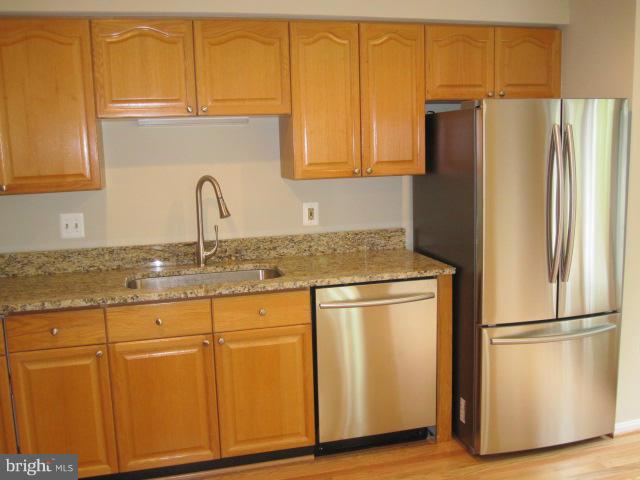 7285 Olde Lantern Way Springfield, VA 22152 - Photo 4 of 7 a kitchen with stainless steel appliances granite countertop a refrigerator sink and cabinets