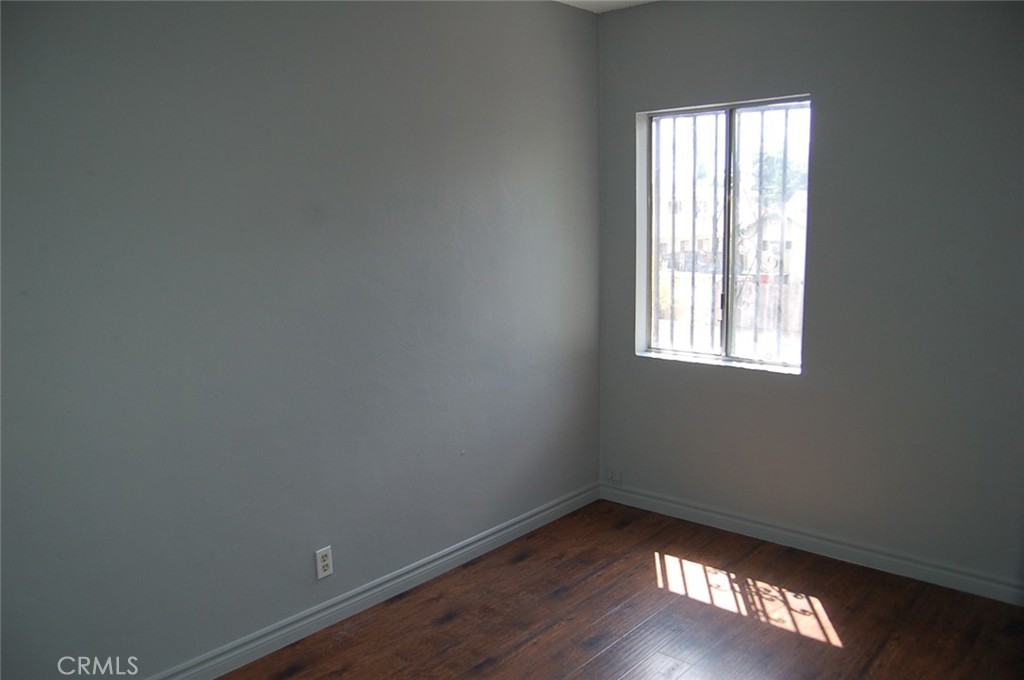 422 West Palm Street, Unit 424 1/2D Compton, CA 90220 - Photo 11 of 17 an empty room with wooden floor and windows