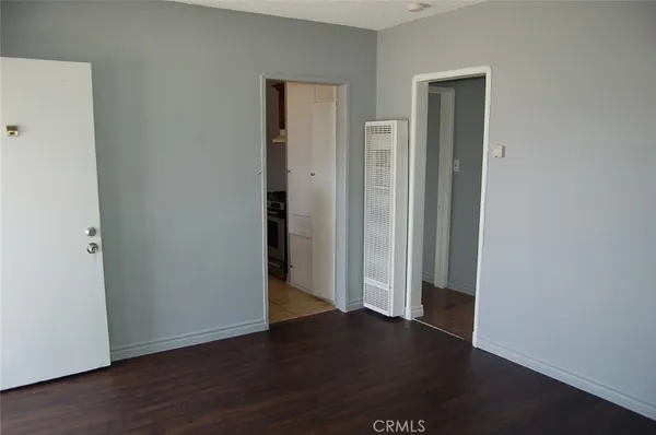 an empty room with wooden floor & closet area
