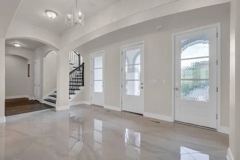 a spacious bedroom with a bed and a chandelier