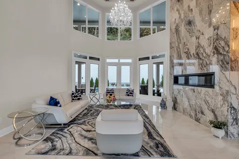 a living room with furniture a fireplace and a large window