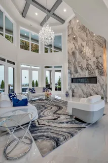 a spacious bedroom with a bed a couch and chandelier