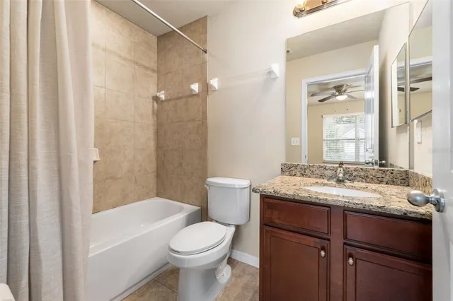 a bathroom with a granite countertop sink a toilet and shower