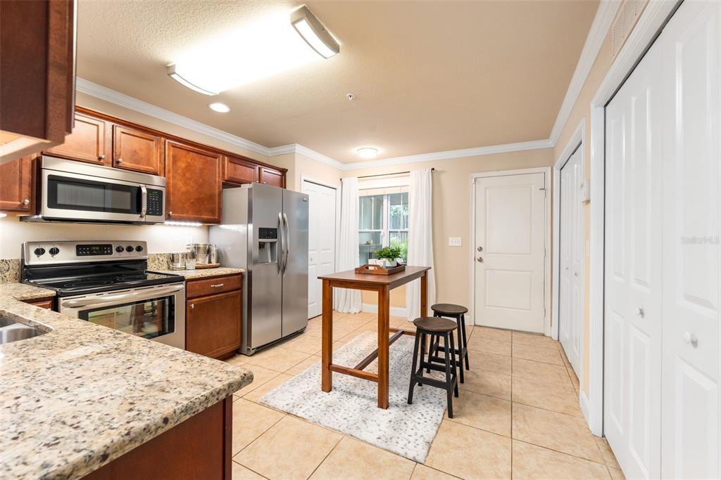 4639 Southwest 48th Drive, Unit 151 Gainesville, FL 32608 - Photo 13 of 26 a kitchen with stainless steel appliances kitchen island granite countertop a refrigerator and a stove top oven