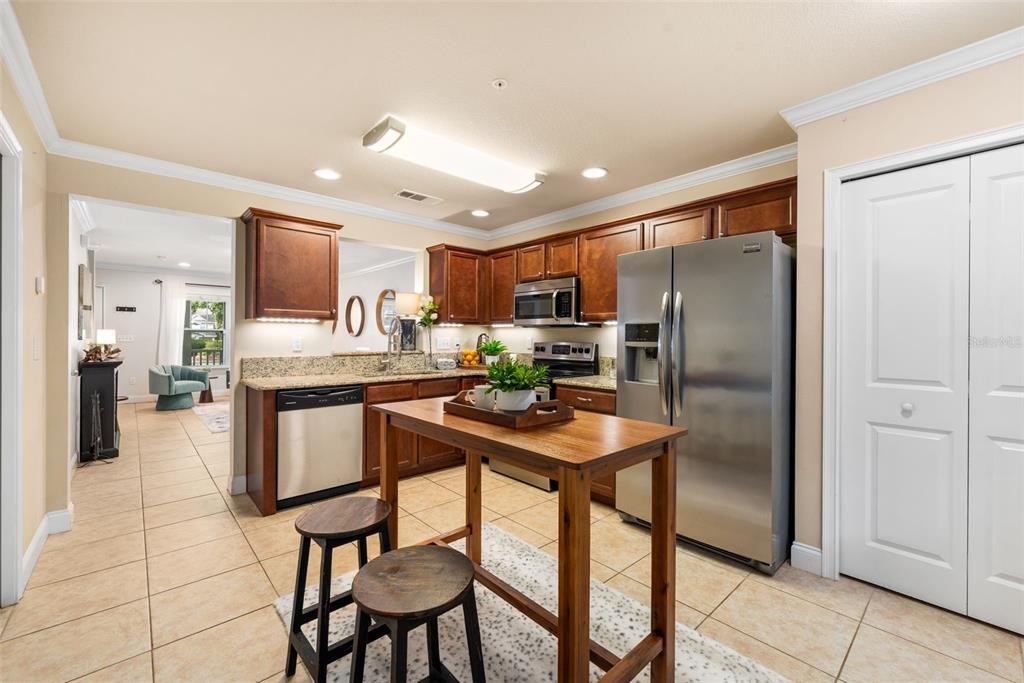 4639 Southwest 48th Drive, Unit 151 Gainesville, FL 32608 - Photo 14 of 26 a kitchen with stainless steel appliances granite countertop a refrigerator a stove a sink dishwasher and white cabinets with wooden floor