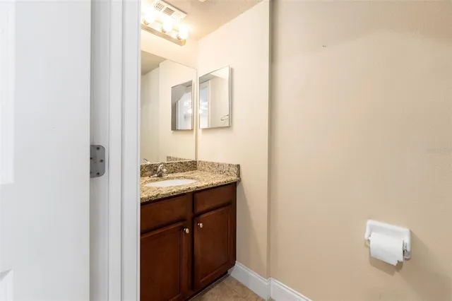 a bathroom with a granite countertop sink and a mirror