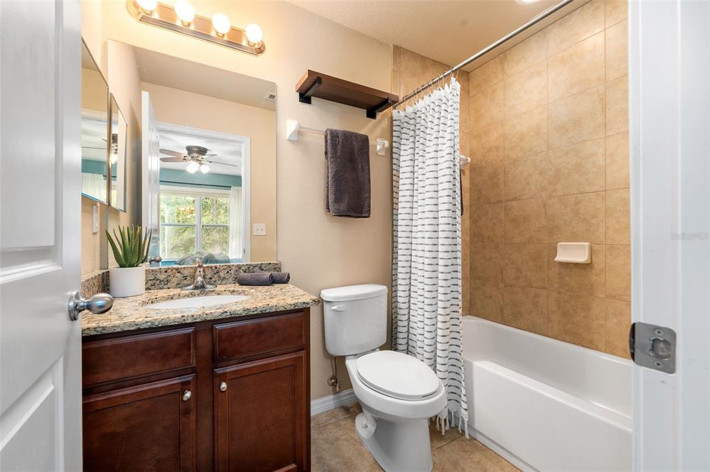 4639 Southwest 48th Drive, Unit 151 Gainesville, FL 32608 - Photo 16 of 26 a bathroom with a granite countertop sink toilet and shower
