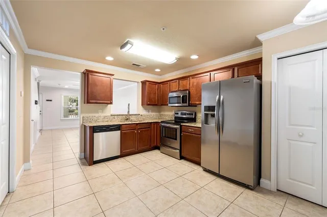 a kitchen with granite countertop a refrigerator and a sink