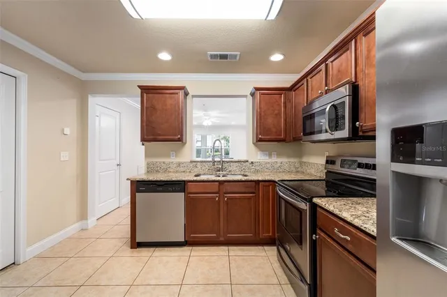a kitchen with stainless steel appliances granite countertop a stove top oven a sink and dishwasher