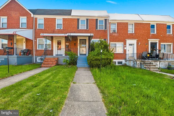 front view of a brick house with a yard