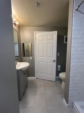 a bathroom with a sink a toilet and mirror