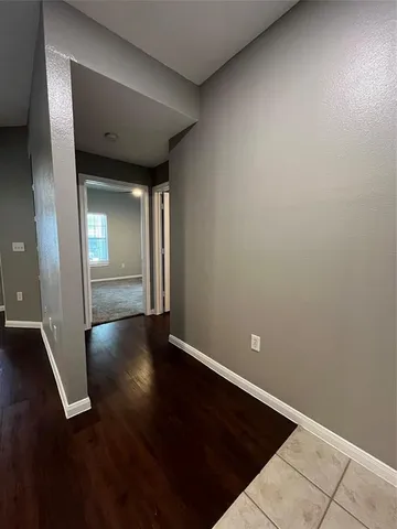 an empty room with wooden floor and closet