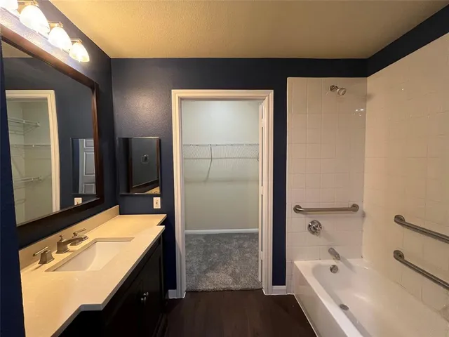 a bathroom with a tub a sink and mirror