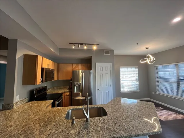 a view of kitchen island a sink wooden floor and living room