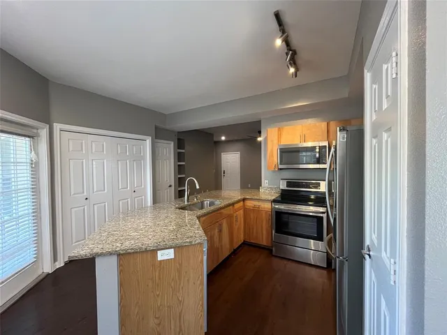 a kitchen with stainless steel appliances granite countertop a sink stove and refrigerator