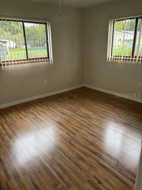 10405 Southwest 98th Terrace Ocala, FL 34481 - Photo 10 of 18 an empty room with wooden floor and windows