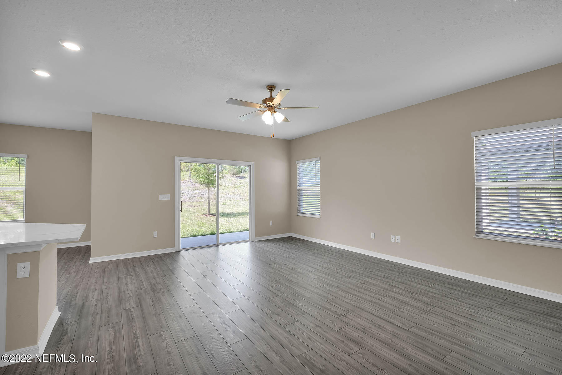 80 Falcon Ridge Road St. Augustine, FL 32084 - Photo 3 of 11 an empty room with wooden floor and windows
