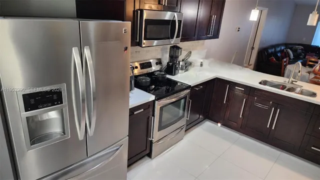 a kitchen with stainless steel appliances granite countertop a refrigerator and a stove