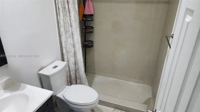 a white toilet sitting next to a bath tub