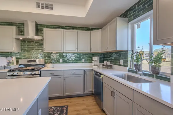 a kitchen with kitchen island wooden floors white appliances cabinets and furniture