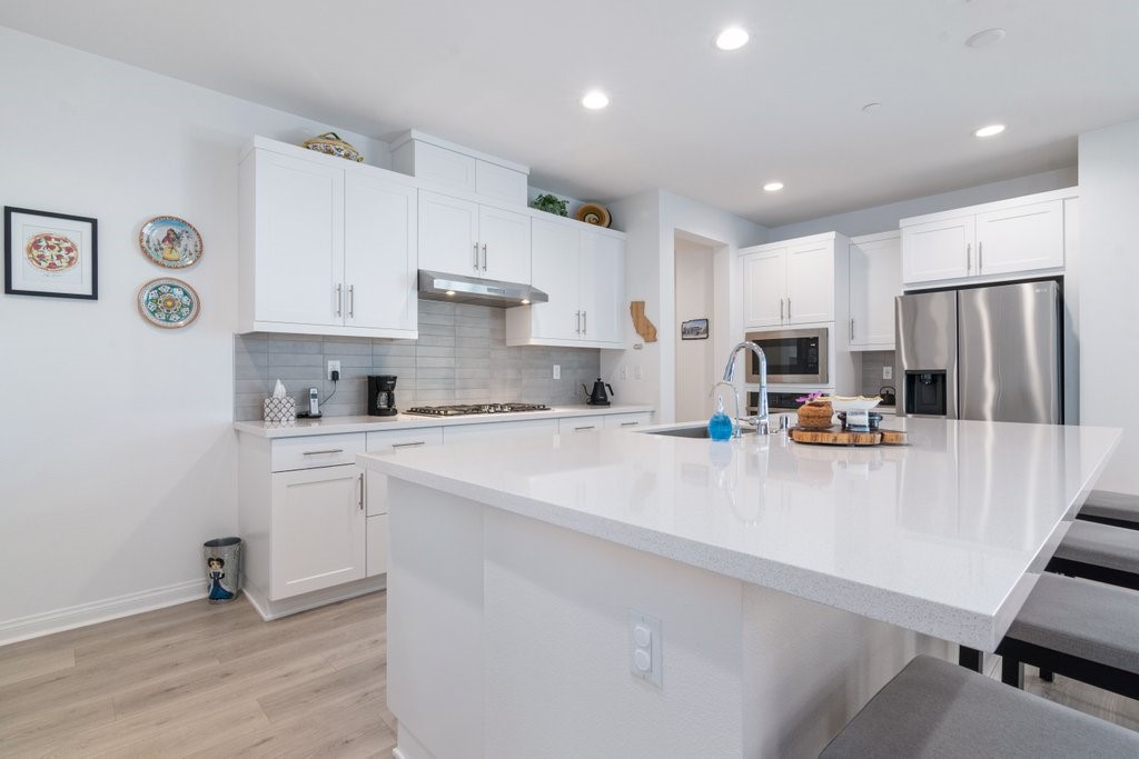 32250 Olea Way Temecula, CA 92591 - Photo 10 of 39 a kitchen with stainless steel appliances a refrigerator sink and white cabinets