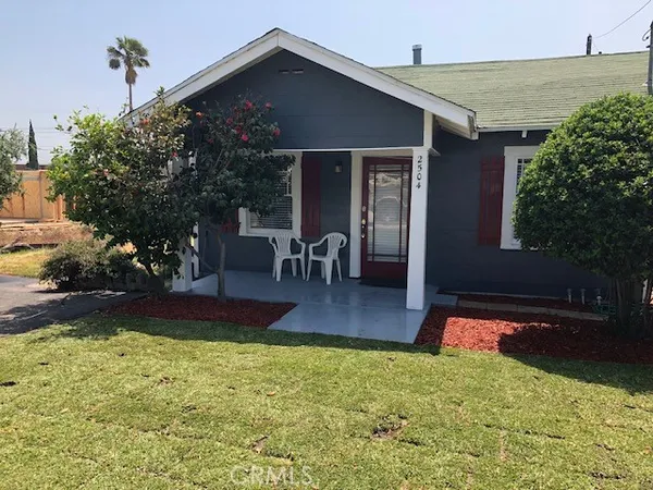 a view of a house with backyard and sitting area