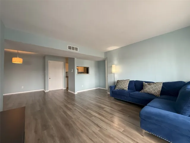 a living room with couches and kitchen view
