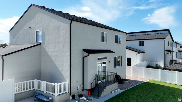 983 South 950 West Provo, UT 84601 - Photo 51 of 56 Modern stucco exterior featuring a tiered deck, white vinyl fencing, and a manicured lawn