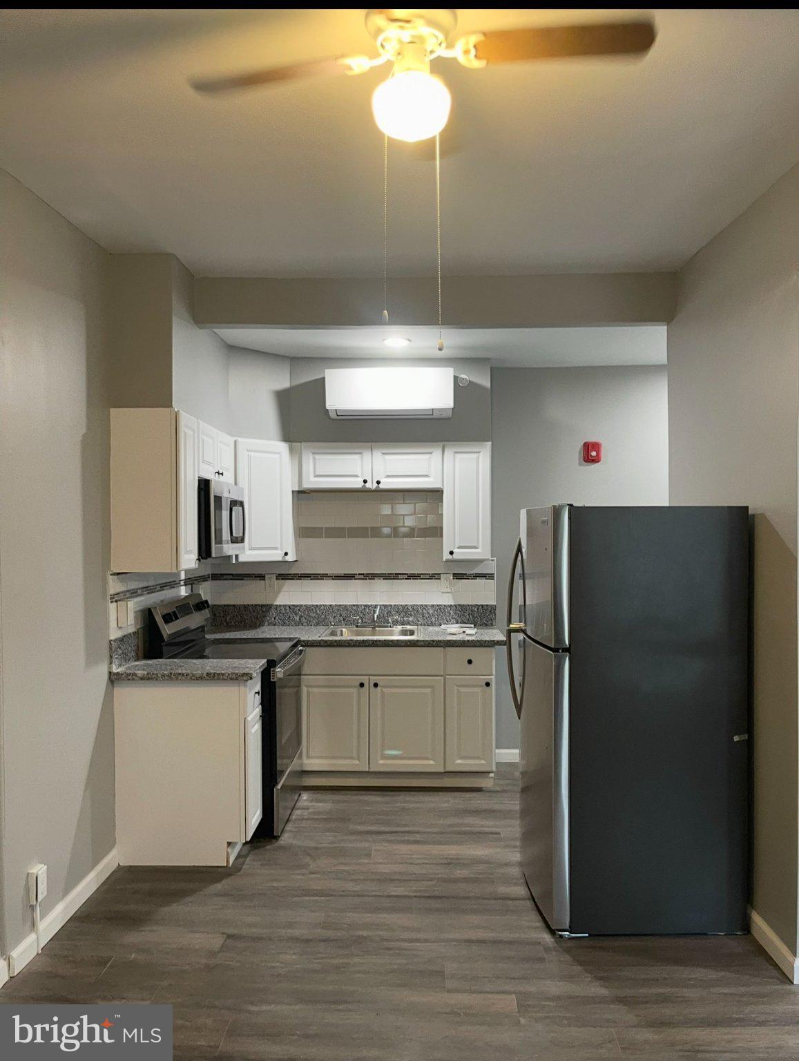 2045 North 8th Street, Unit 3 Philadelphia, PA 19122 - Photo 3 of 9 a kitchen with granite countertop a refrigerator and a stove top oven