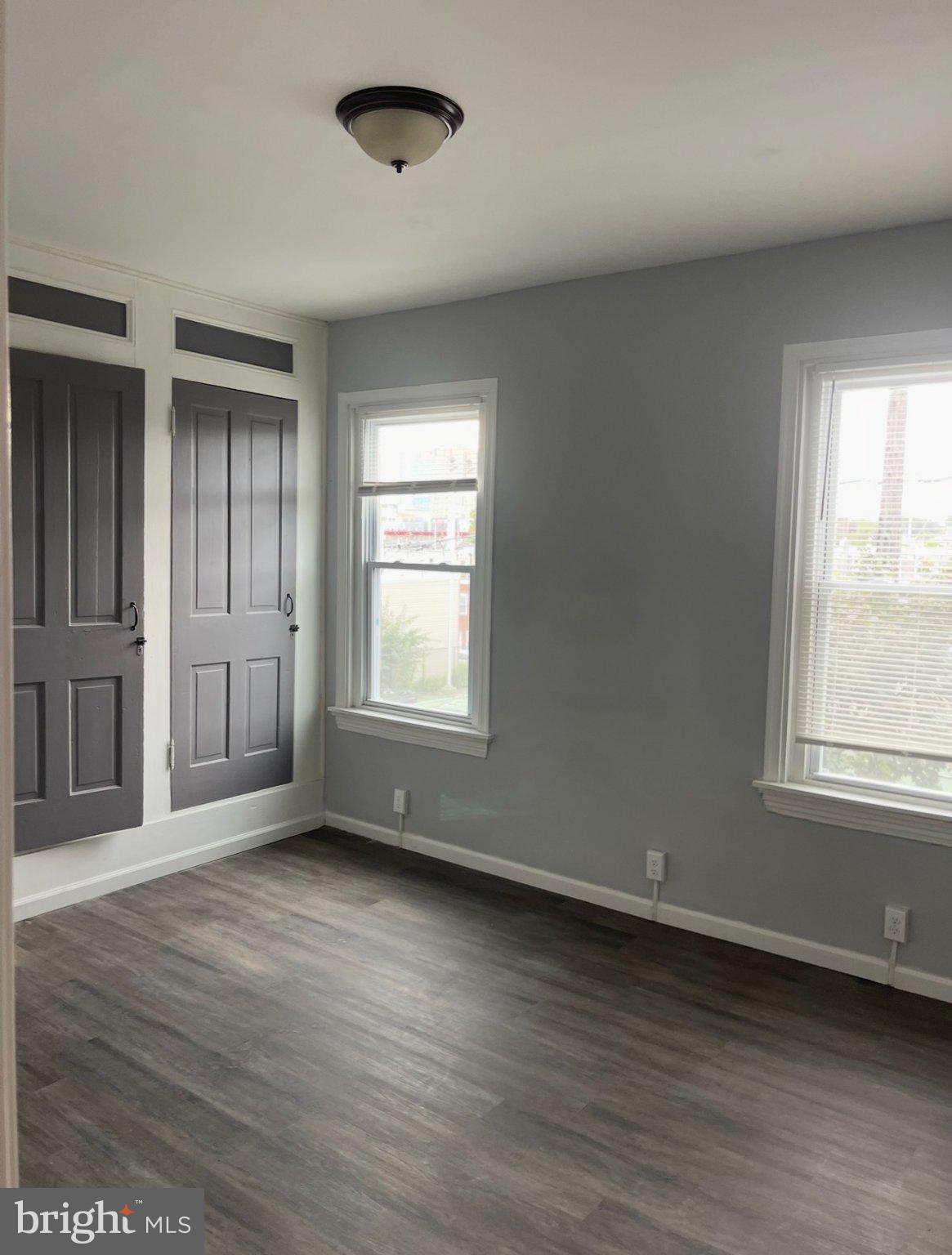 2045 North 8th Street, Unit 3 Philadelphia, PA 19122 - Photo 6 of 9 an empty room with wooden floor and windows