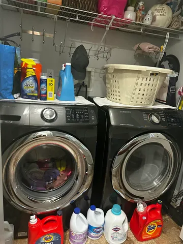 a utility room with stainless steel appliances a stove and a wooden floor