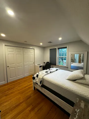 a bedroom with a bed and wooden floor
