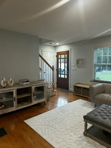 a living room with furniture and a wooden floor