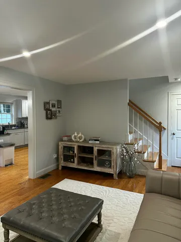 a living room with furniture and a wooden floor