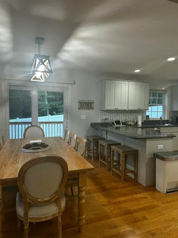 a kitchen with granite countertop a table chairs stove and cabinets