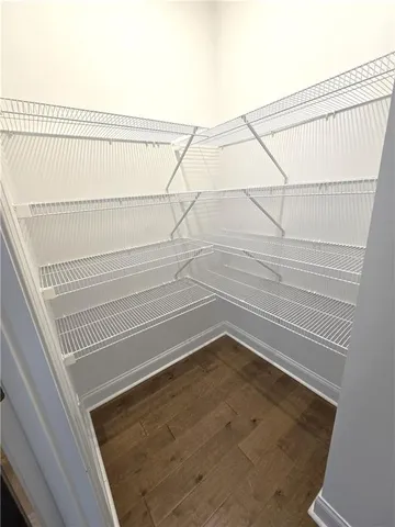 a view of kitchen with refrigerator stove and wooden floor