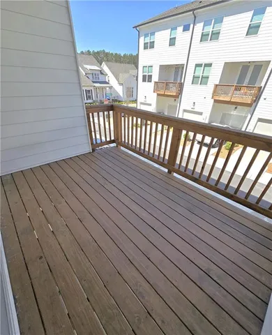 an empty room with wooden floor fireplace and windows