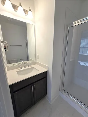 a bathroom with a granite countertop toilet and a shower