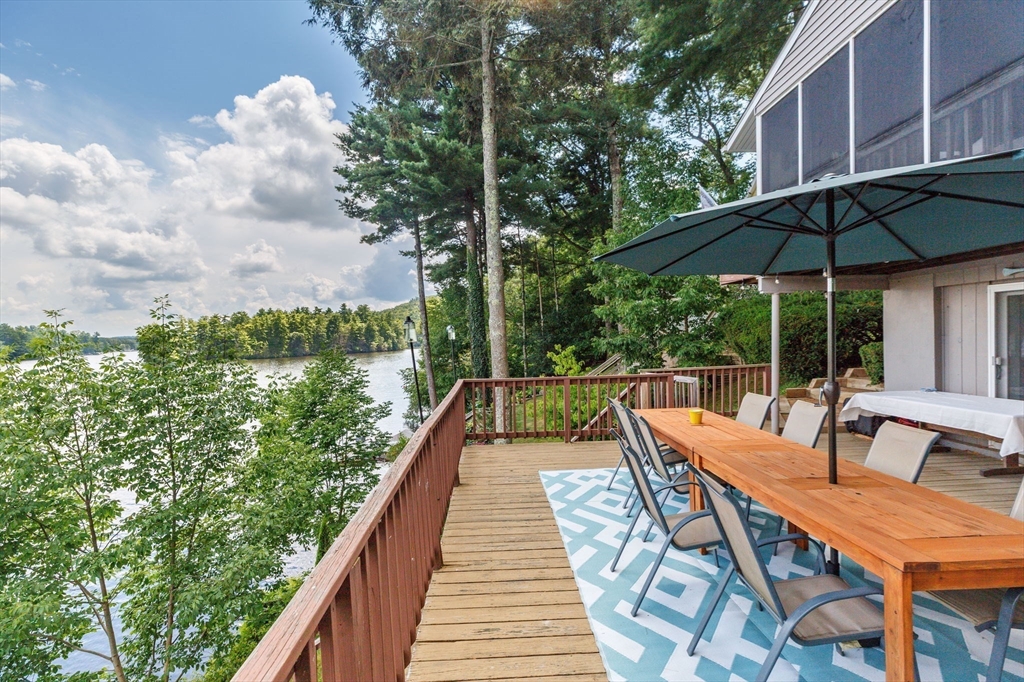 53 Sandy Beach Road Holland, MA 01521 - Photo 14 of 40 a view of a patio with couches table and chairs under an umbrella